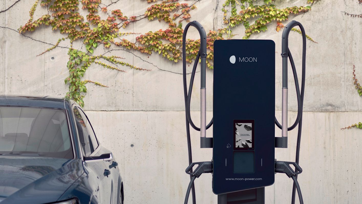 E-Auto steht neben einer Schnellladestation