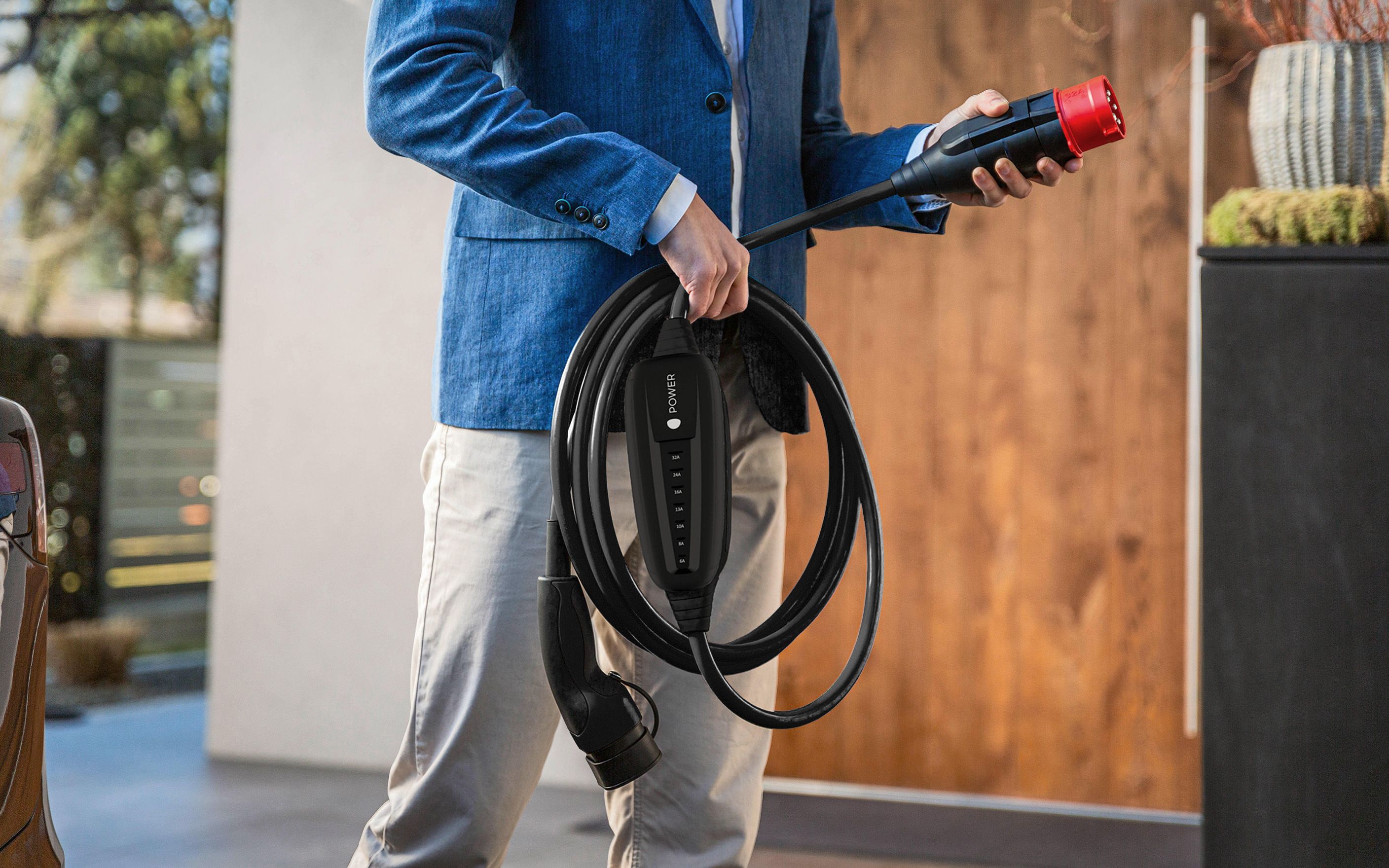 ein Mann hält den Stecker eines POWER2Go Kabels in der Hand