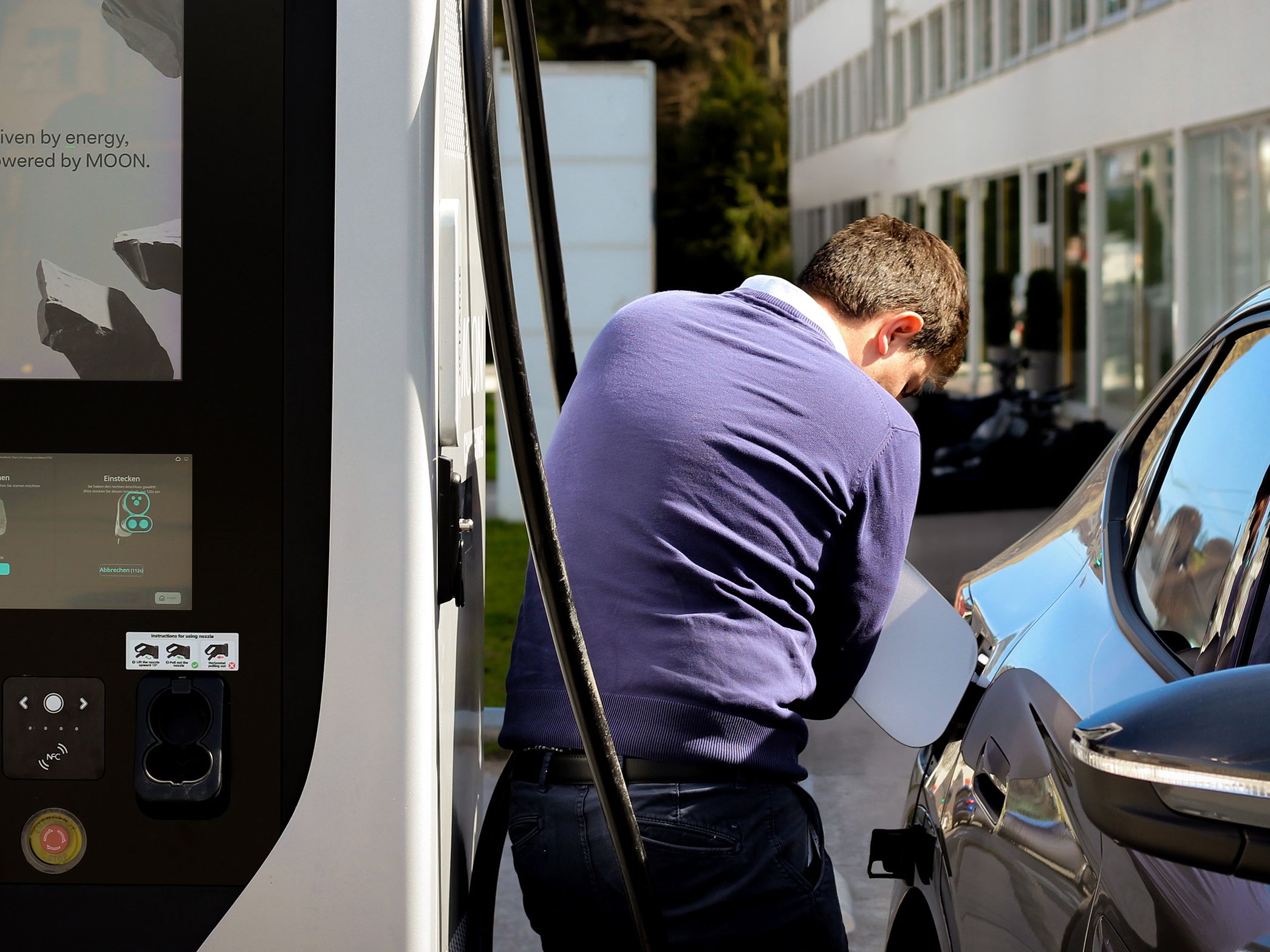 Mann öffnet Tankdeckel des Autos