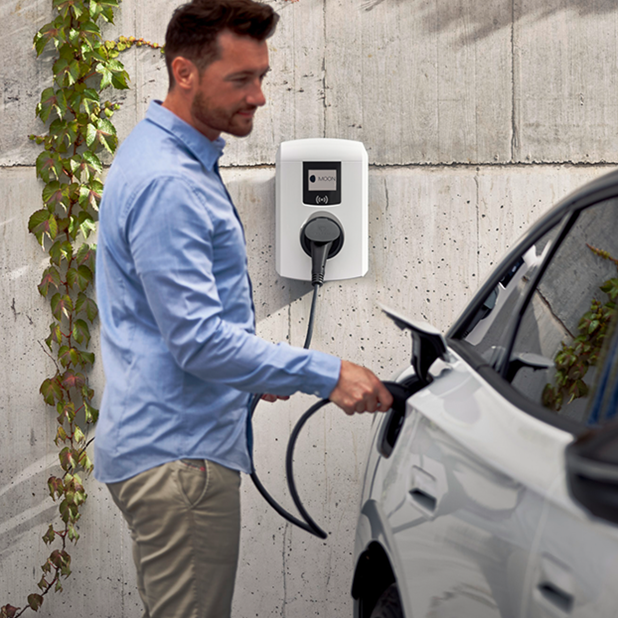 Mann lädt E-Auto mit einer Wallbox