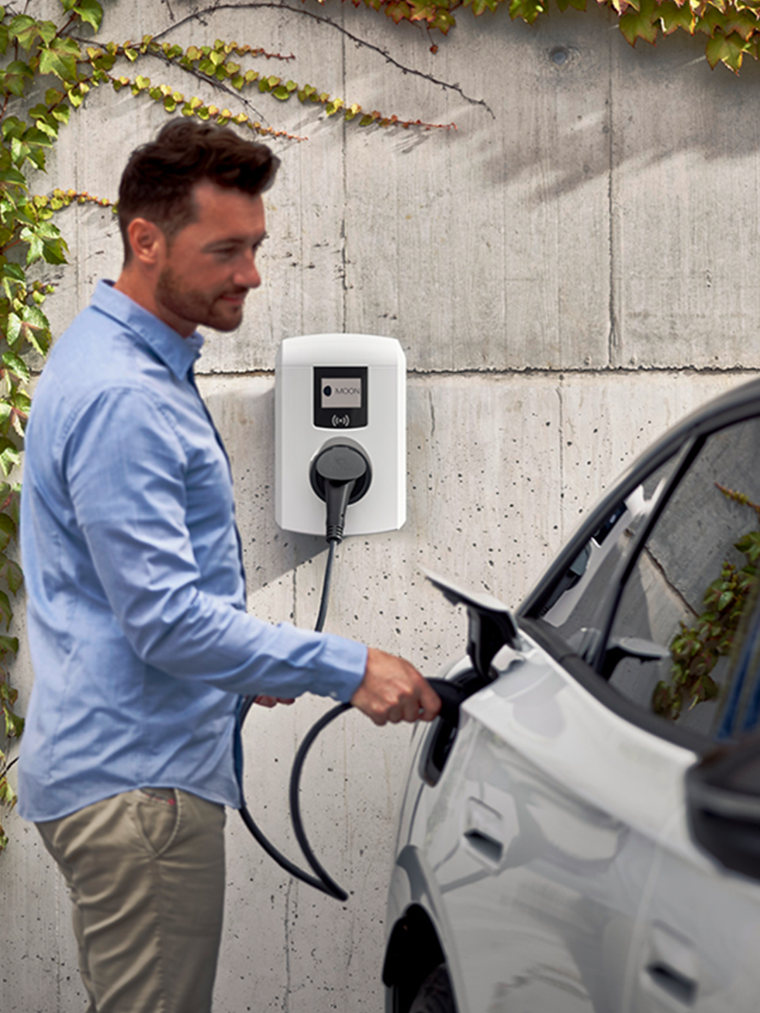 Mann lädt E-Auto mit einer Wallbox