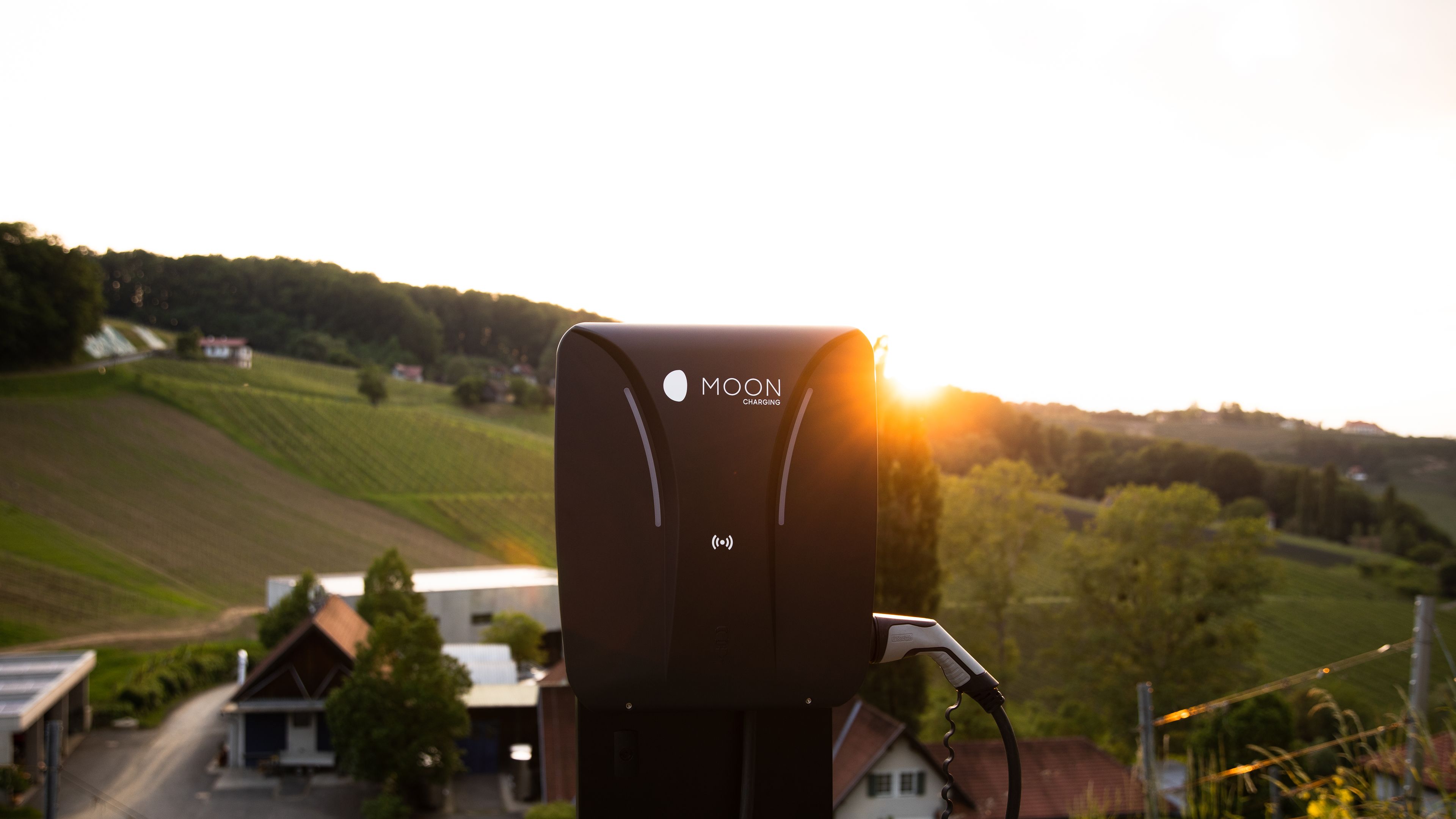 MOON-Ladestation vor Landschaft mit Sonne