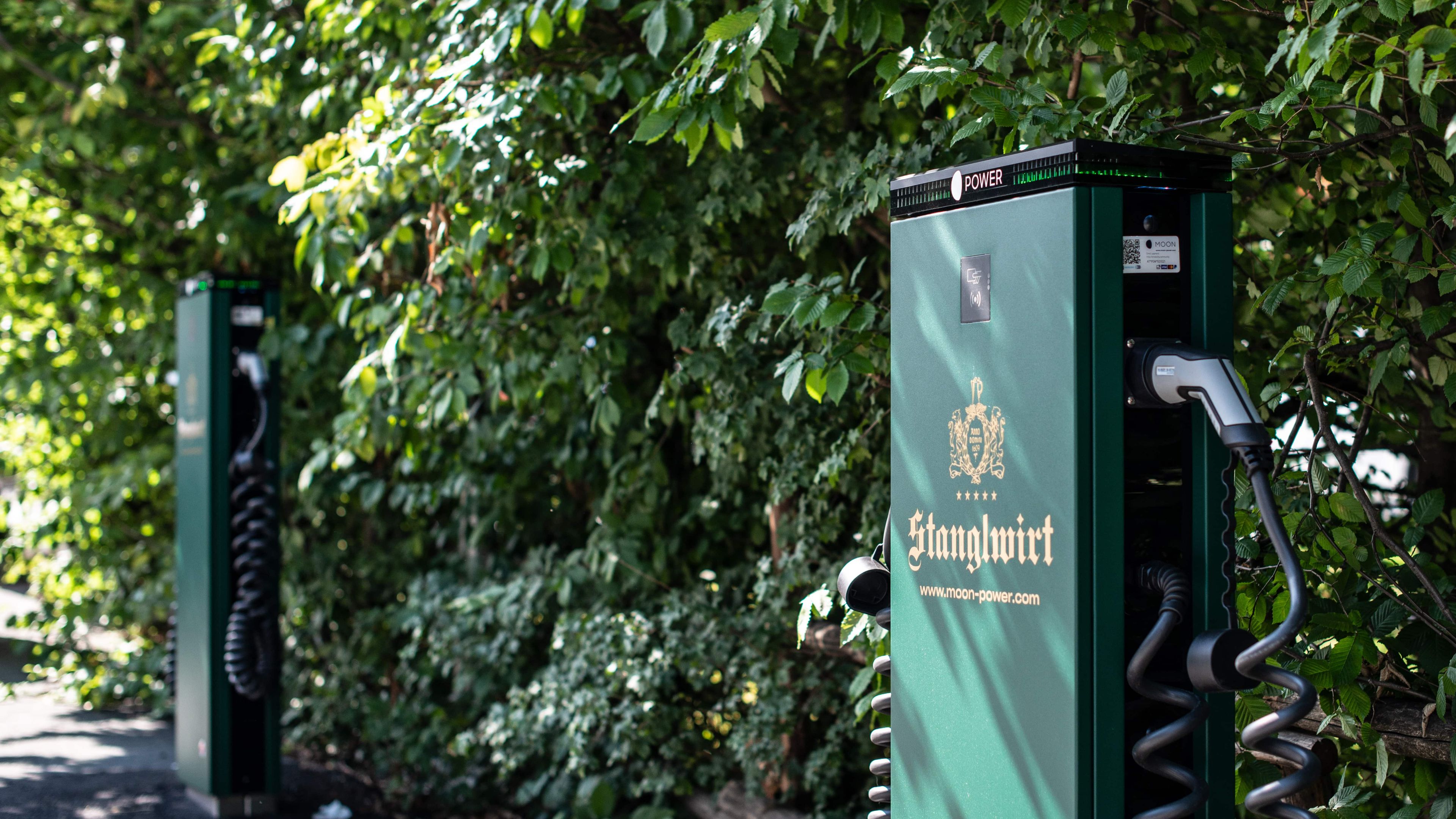 Gebrandete Ladestation vor Hecke