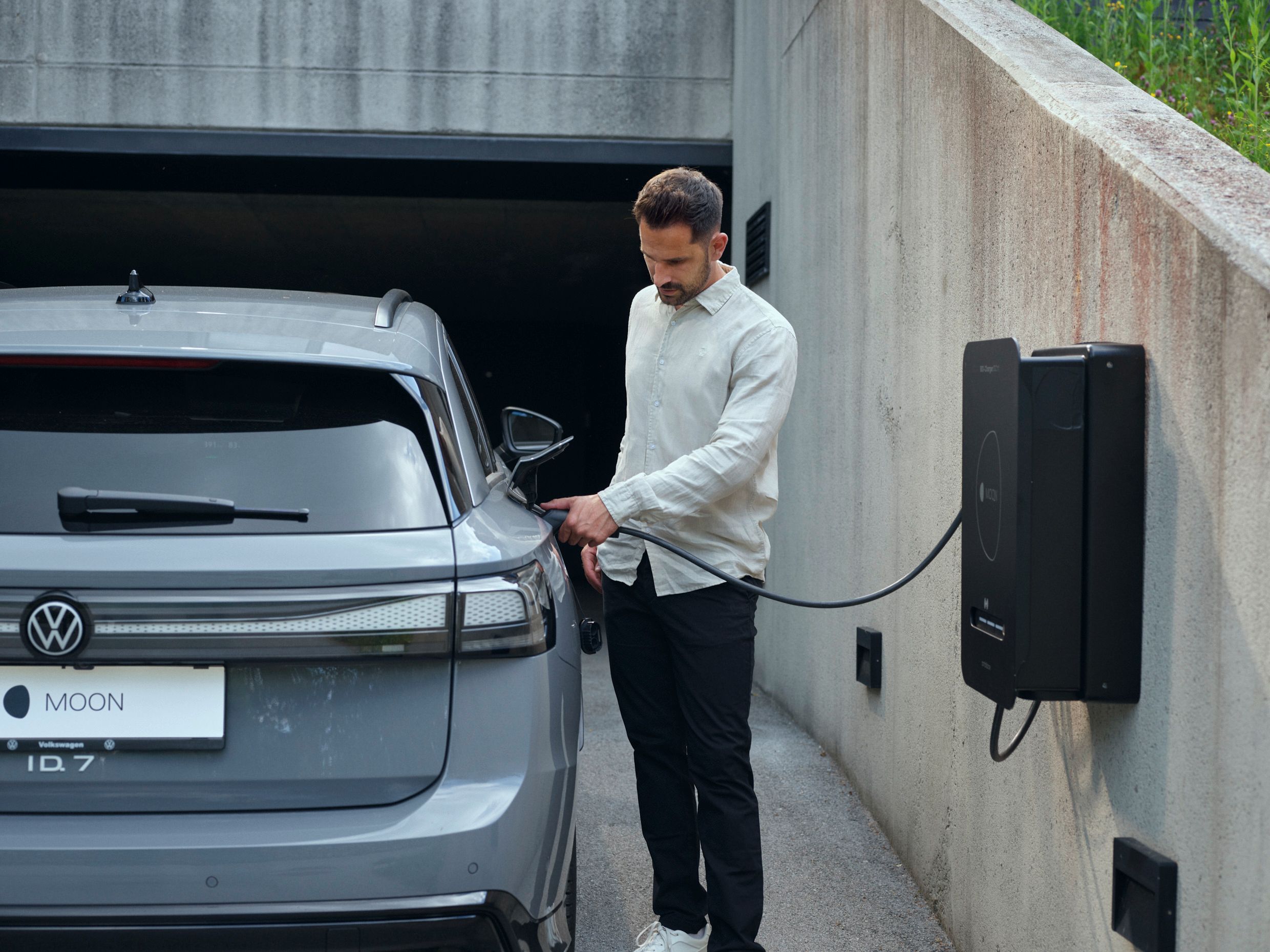 Mann steckt Auto an Bidirektionale Wallbox BiDi Charger 11 DC an