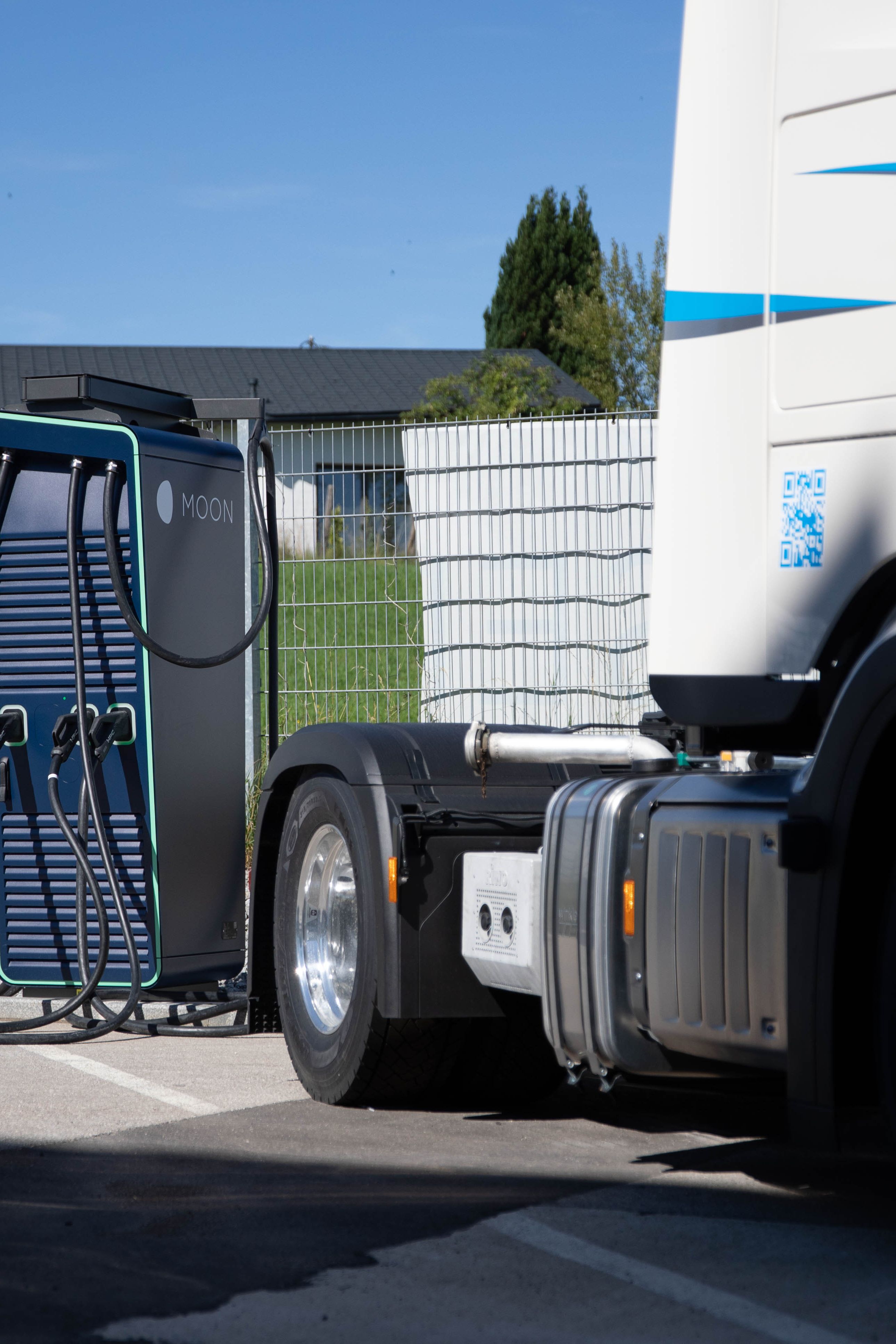 ein Mann geht zu einer HYC 200-400 Schnelladestation neben einem LKW