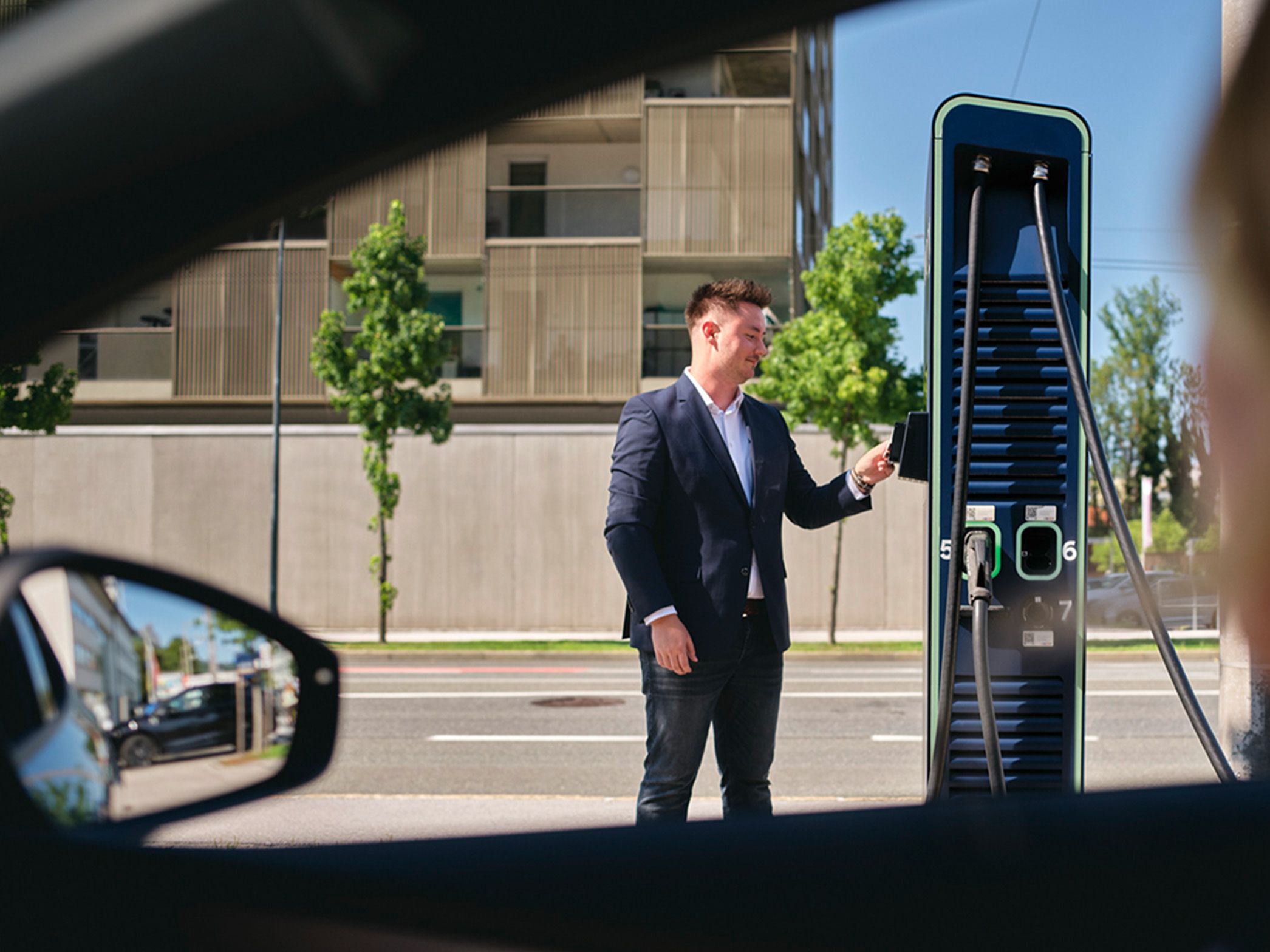 Person hält Karte an eine Ladestation