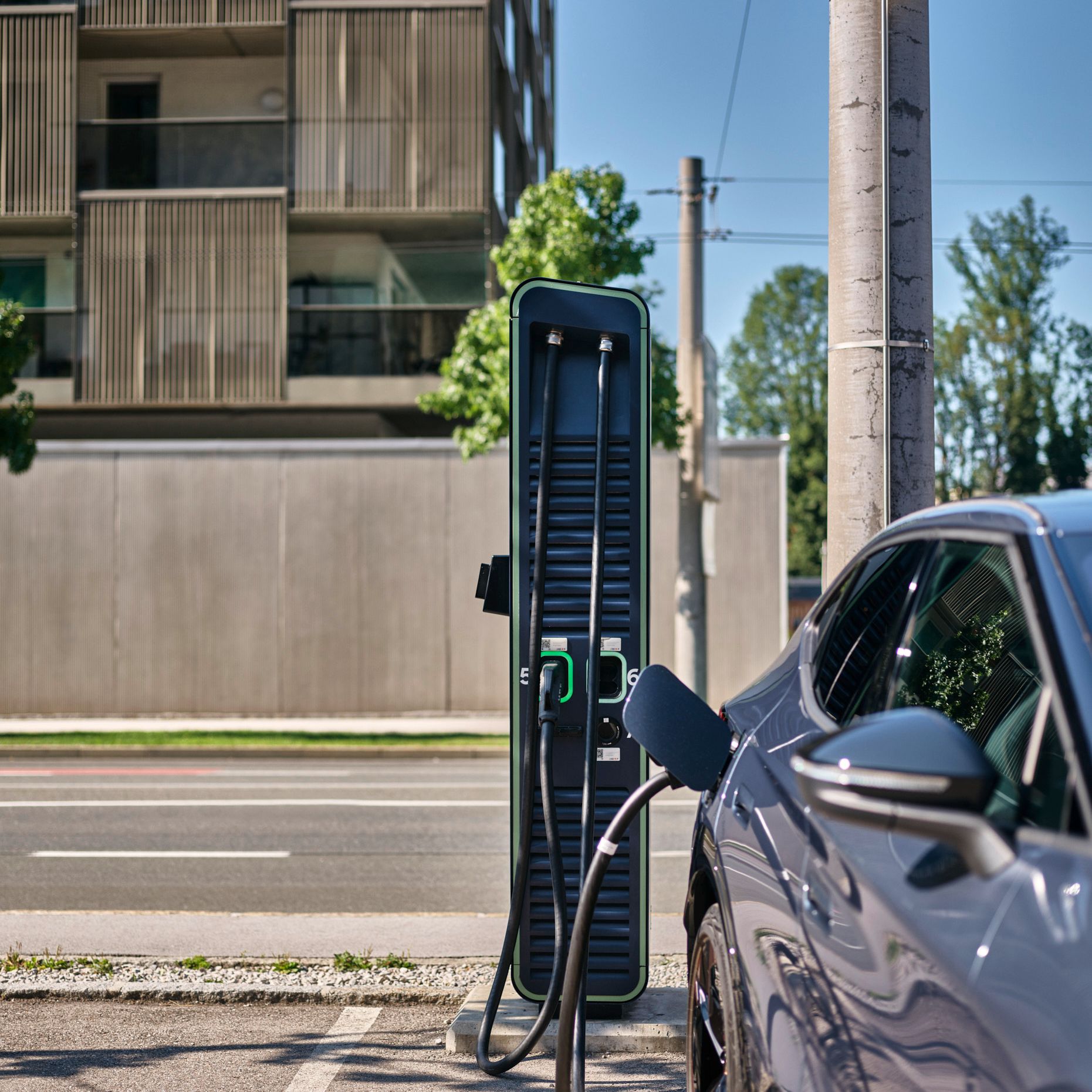 E-Auto an eine Schnellladestation angesteckt auf einem Parkplatz